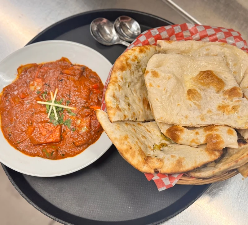 Curry with a basket of fresh tandoori naan at Tamarind Regina South